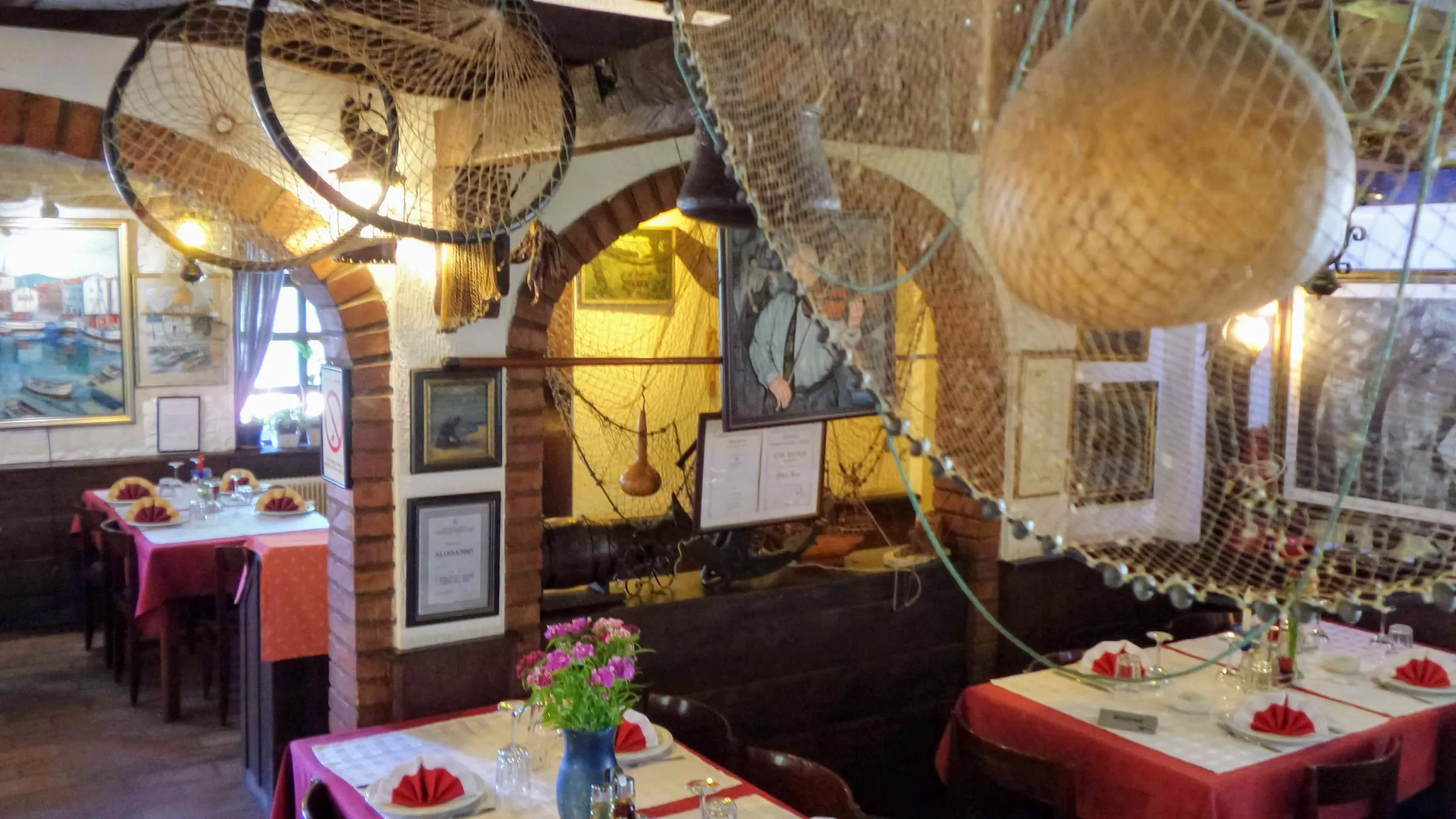 Sala restorana sa lukovima od cigle i ribarskim mrežama
